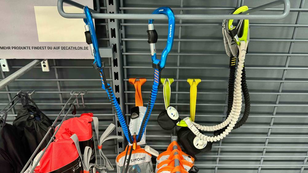 Getestet: Ein Klettersteigset hängt an Karabinern befestigt an einem Regal.