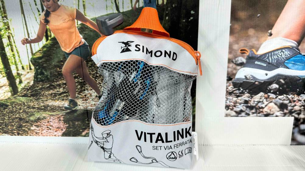 Ein Klettersteigset im Test in seiner Originalverapckung vor einem Plakat.