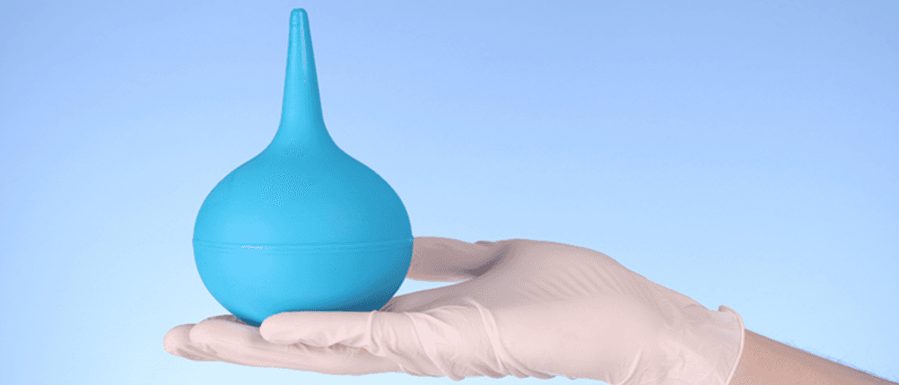 Klistierspritze im Test: Eine Hand mit Handschuhen hält eine Klistierpumpe