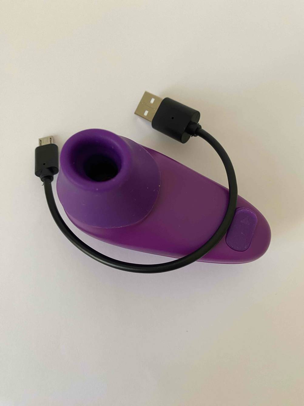 Klitorissauger-Test: Das Gerät auf einer hellen Fläche, darüber liegt das Ladekabel.