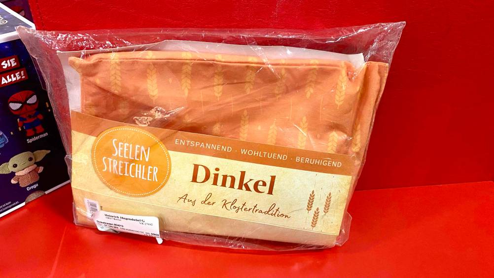 Im Test: Ein Dinkelkissen vor einer roten Fläche.