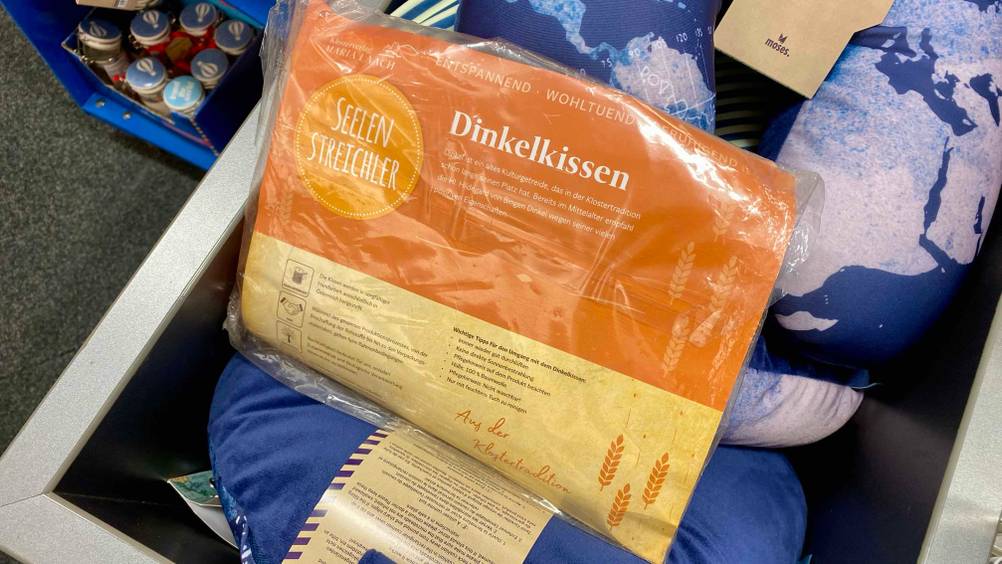 Dinkelkissen getestet: Die Rückseite des verpackten Kissens auf anderen Kissen.
