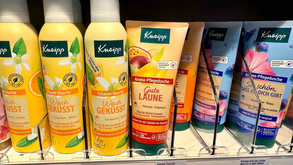 Duschgel ohne Mikroplastik im Test: Mehrere Tuben stehen zwischen anderen Pflegeprodukten in einem Regal.