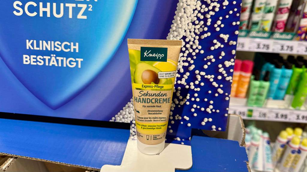 Eine Tube mit Kneipp-Handcreme im Test steht vor einem Drogeriemarktregal.