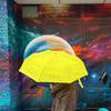 Regenschirm-Test: Gelber Regenschirm vor bemalter Wand