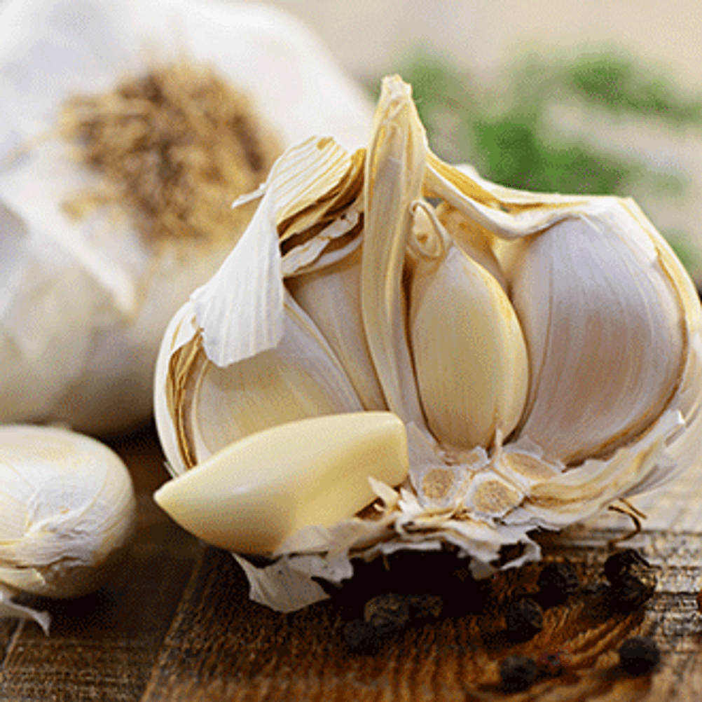 Knoblauchknolle mit einzelnen Knoblauchzehen als Mittel gegen Schnarchen.