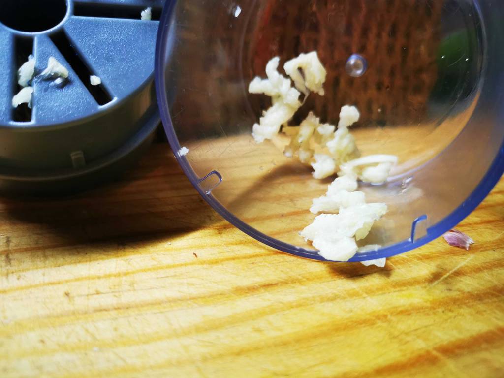Geschnittener Knoblauch liegt im Auffangbehälter eines getesteten Knoblauchschneiders.