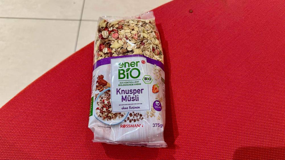Eine Packung des getesteten Knusper-Müslis von oben auf einer roten Fläche.