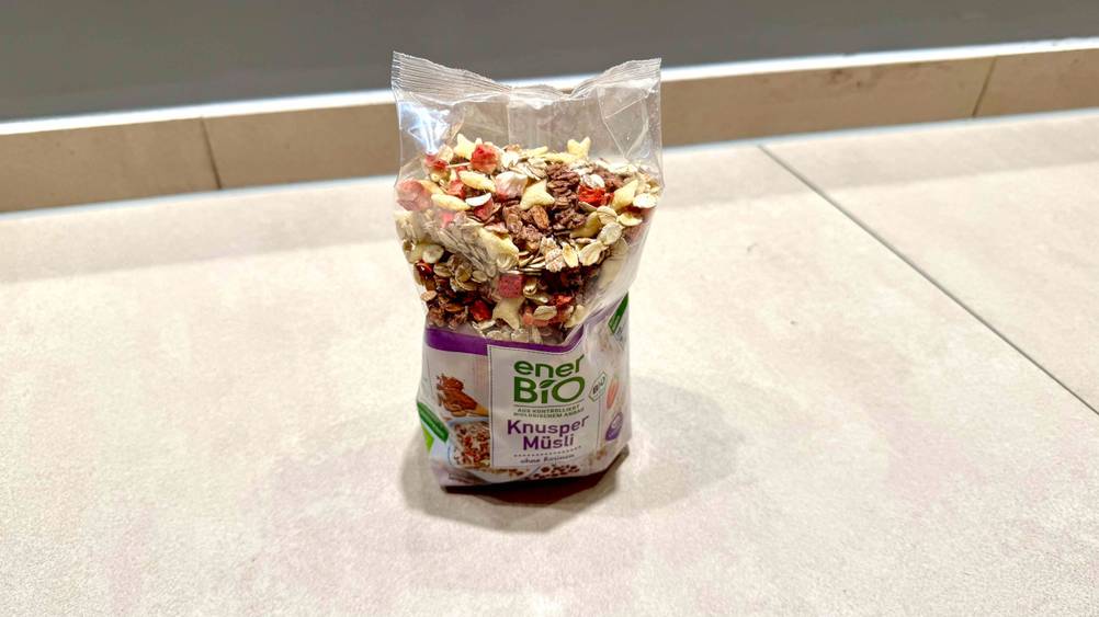Eine Packung des getesteten Knusper-Müslis von schräg oben auf einem hellen Boden.