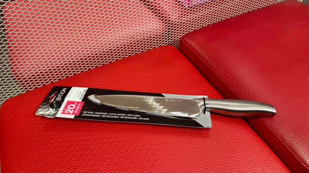 Ein getestetes Kochmesser 20 cm auf einem roten Polster liegend.