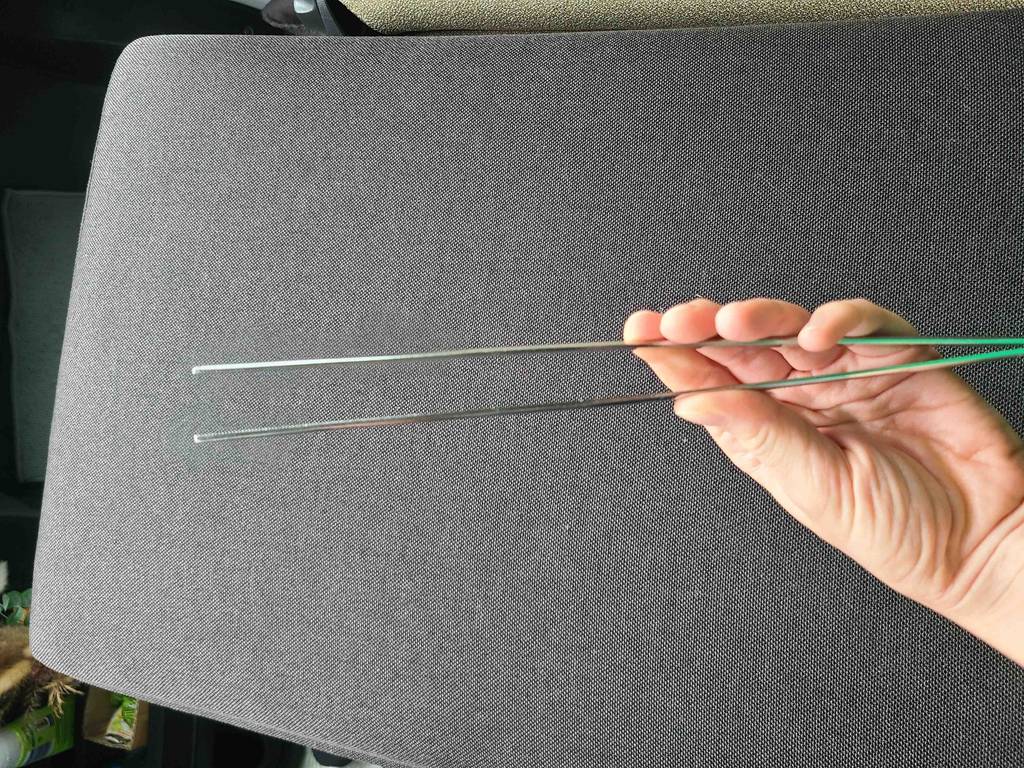 Im Test: Eine Hand hält eine Kochpinzette.