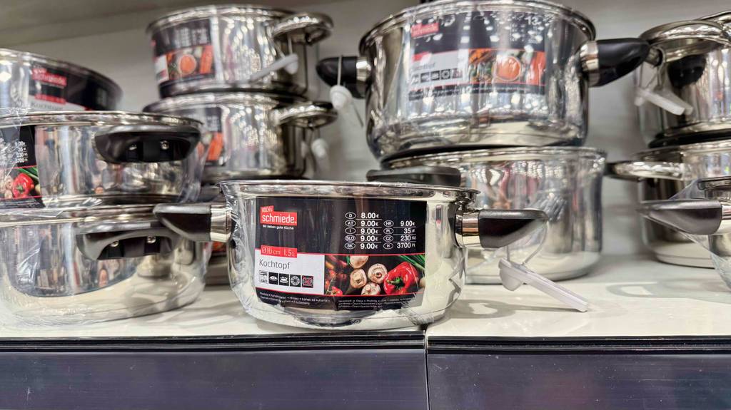 Mehrere 16-cm-Kochtöpfe im Test befinden sich ohne Deckel übereinander in einem Verkaufsregal.