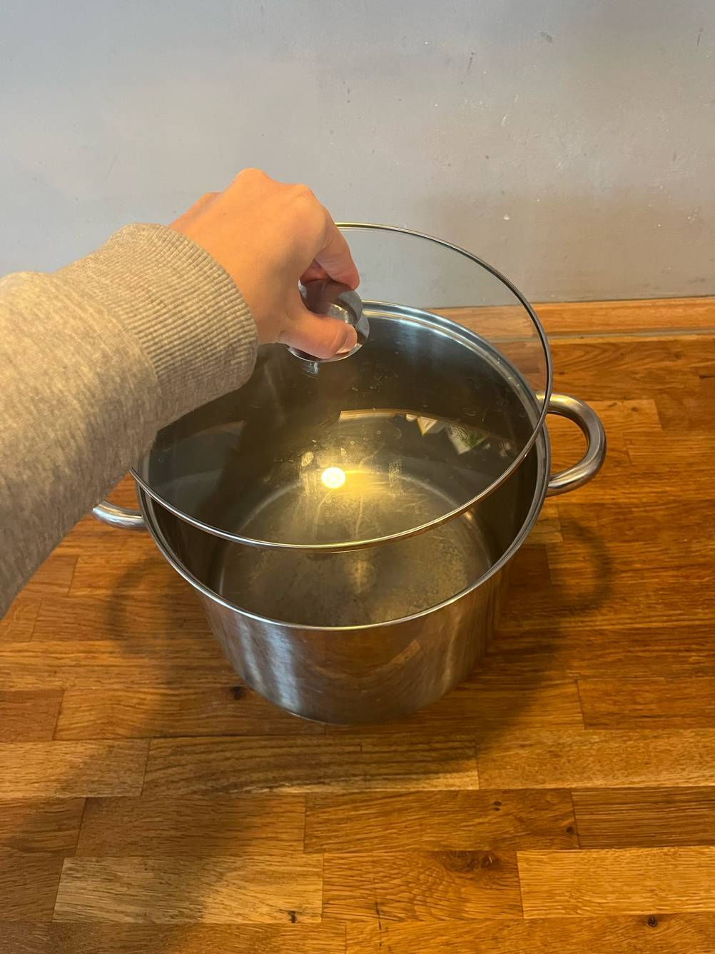 Eine Hand hebt den Deckel eines 15-Liter-Kochtopf im Test.