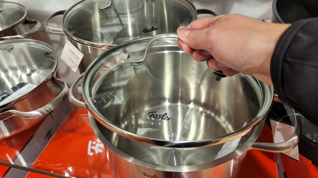 Eine Hand hebt den Deckel eines Kochtopfes im Test hoch.