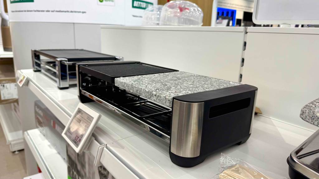 Seitliche Ansicht auf den getesteten Raclette-Grill mit Steinplatte, der auf einem Ausstellungsregal im Grill-Geräte-Bereich steht.