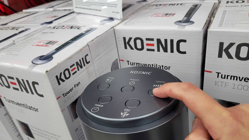 Turmventilator-Test: Eine Hand drückt auf eine Bedientaste auf einem Gerät.
