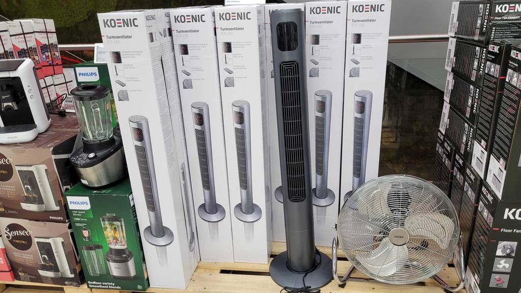 Ein Turmventilator steht zum testen vor einigen verpackten Geräten.
