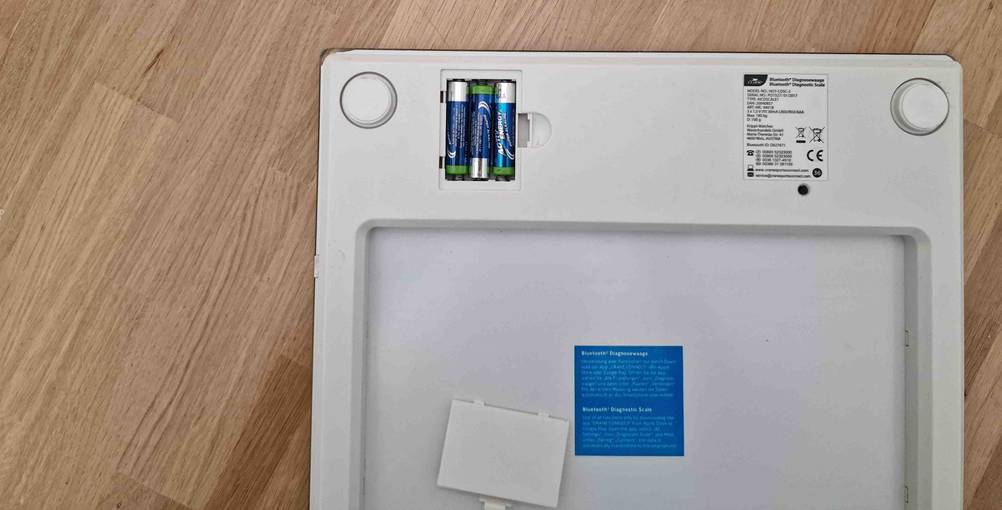 Körperfettwaage getestet: Rückseite mit Informationen und Batteriefach.