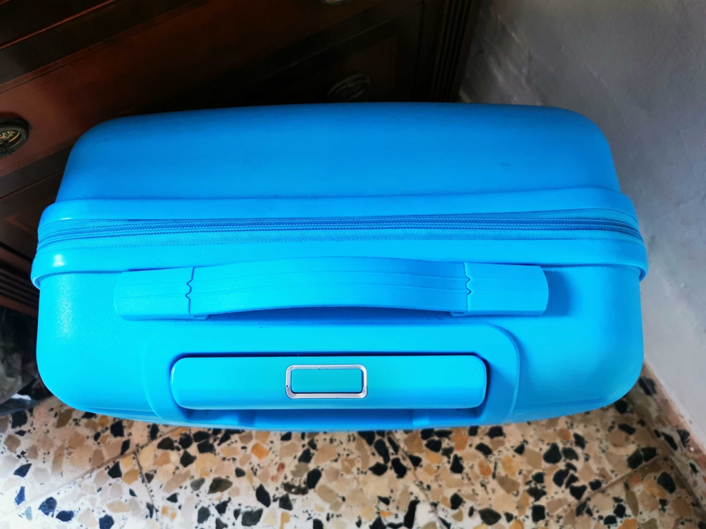 Koffer getestet: Ein geschlossener türkisfarbener Koffer liegt auf dem Boden.