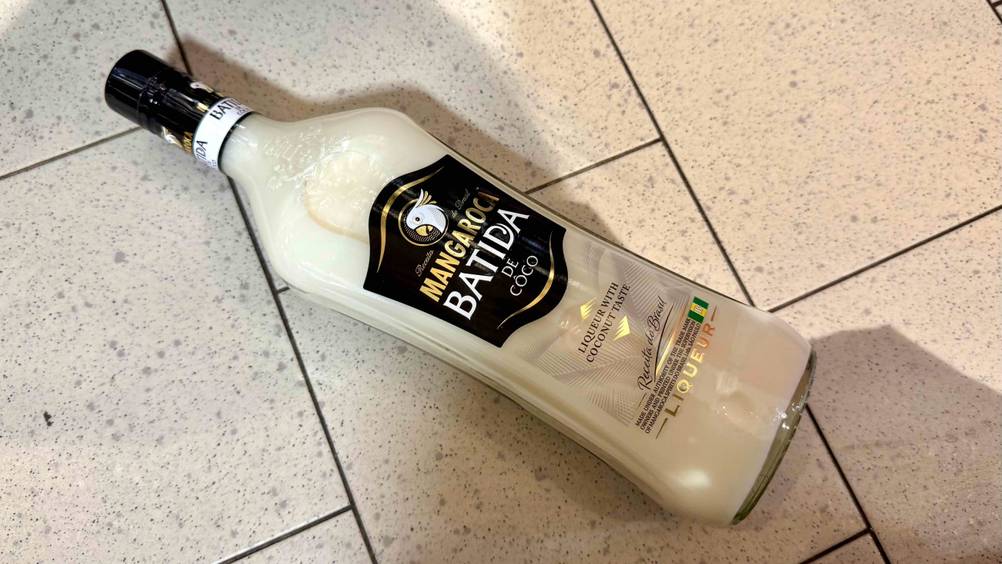 Auf einem Fließenboden liegt eine Flasche des Kokos-Likörs im Test.