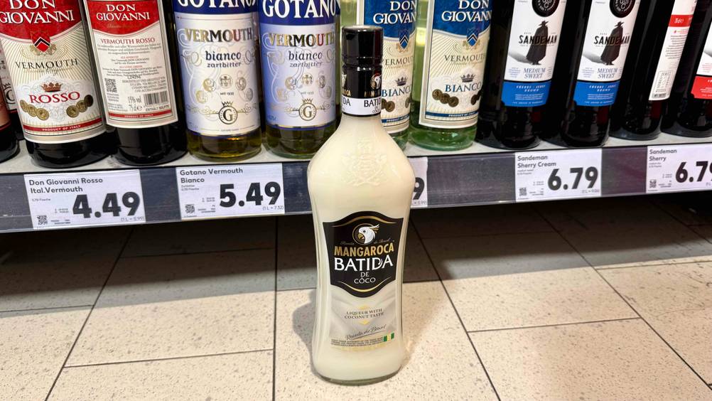 Vor einem Regal steht der Kokos-Likör im Test auf dem Boden.