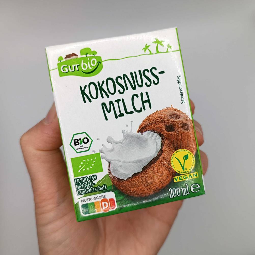 eine Packung Kokosmilch in der Hand