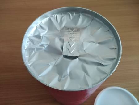 geöffneter Deckel der Verpackung, jedoch eine Schutzfolie zum richtigen Öffnen