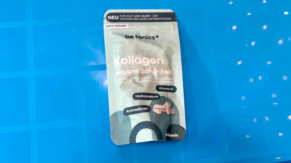 Eine Packung des getesteten Kollagen vegan liegt auf einer blauen Fläche.