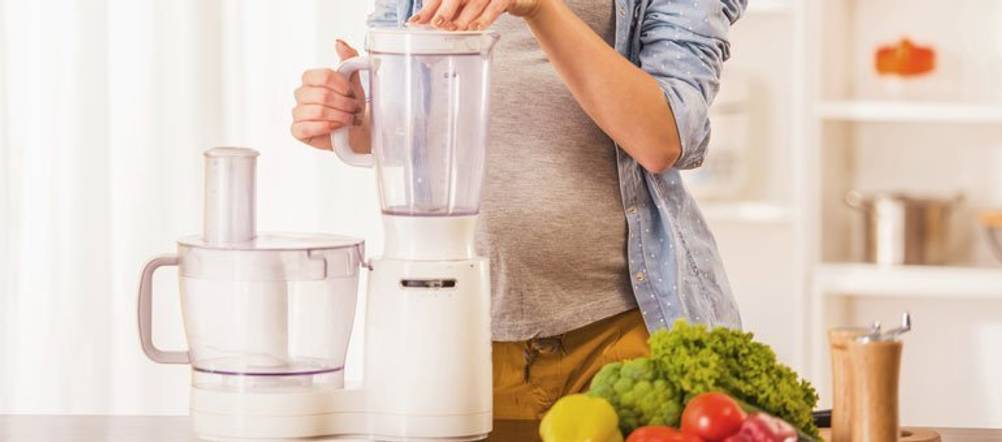 ein Mensch nutzt eine Kompakt-Küchenmaschine