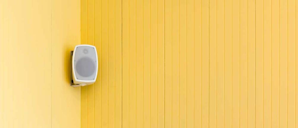 Einsamer Lautsprecher an gelber Wand