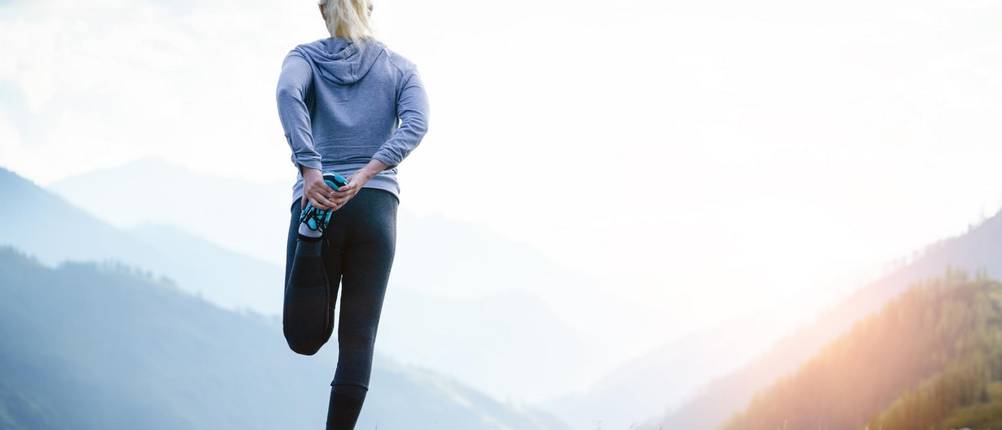 Kompressions-Laufhose Damen Test: Eine Frau macht Aufwärm- und Stretching-Übungen.