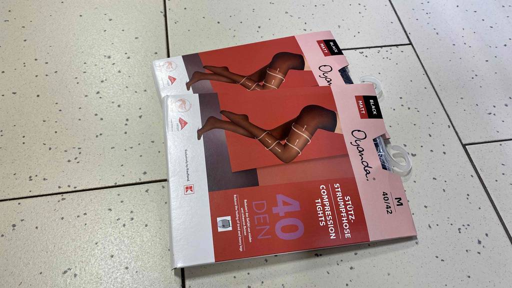 Zwei Packungen getestete Kompressionsstrumpfhosen befinden sich auf dem Boden. 