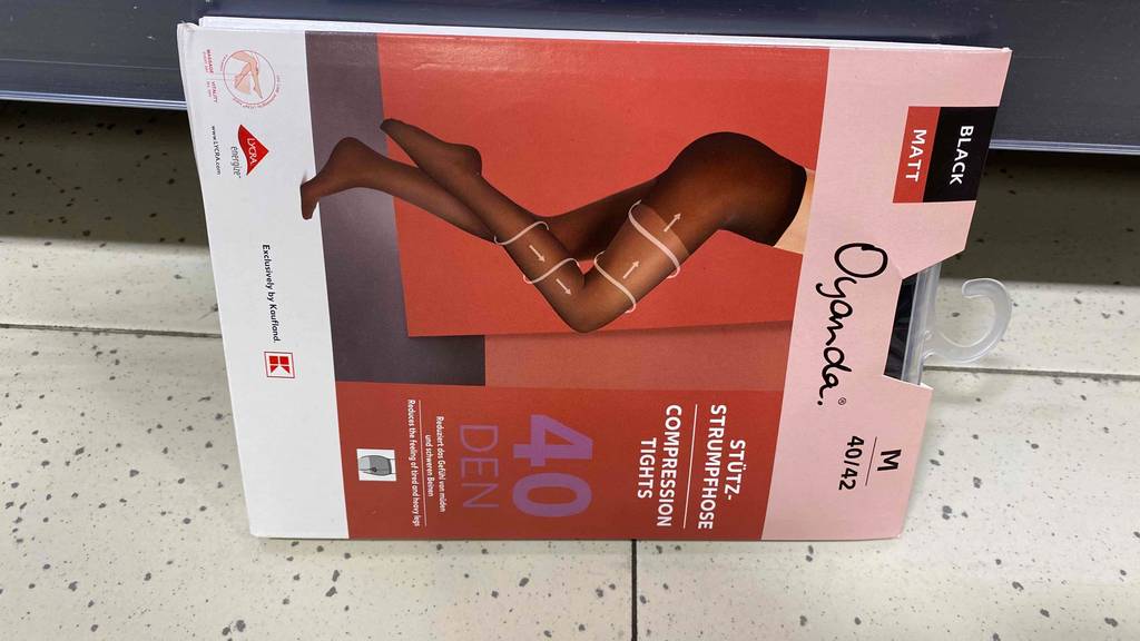 Eine Packung getestete Kompressionsstrumpfhose liegt an der Wand an. 