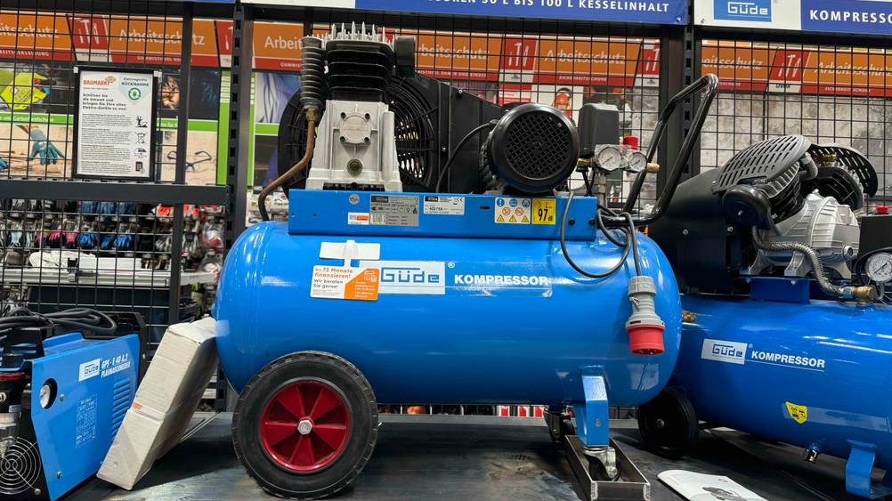 Getestet: Seitenansicht eines Kompressors 100l neben anderen Produkten auf einem Regal.