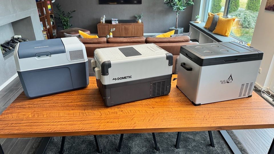 Drei Kompressor-Kühlboxen stehen nebeneinander auf einem Tisch