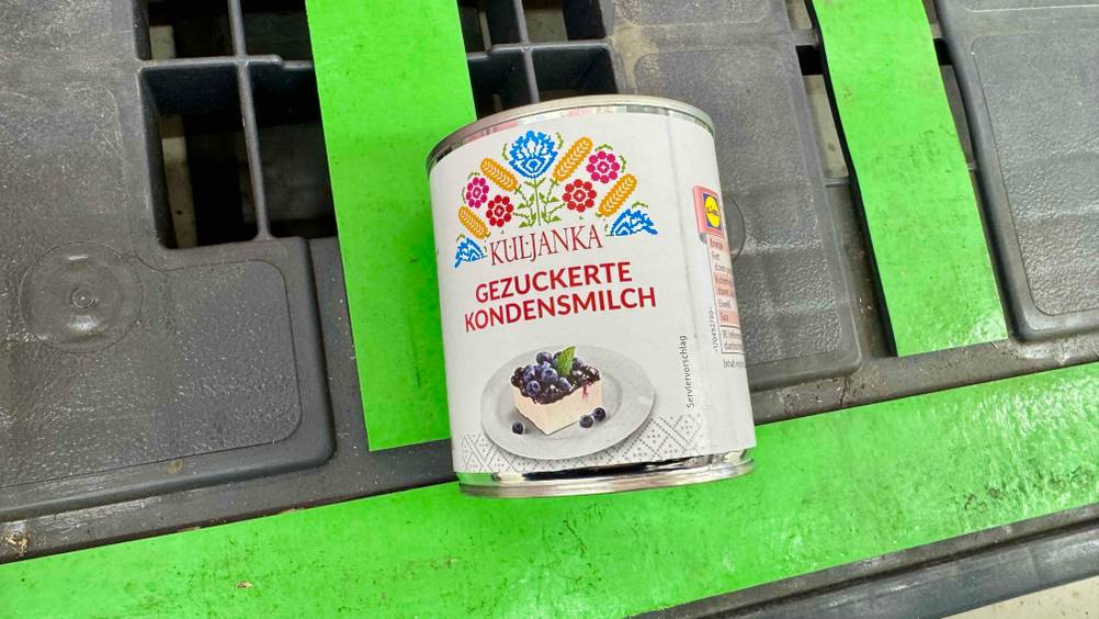 Auf einer grün-grauen Palette liegt eine Dose der getesteten Kondensmilch.