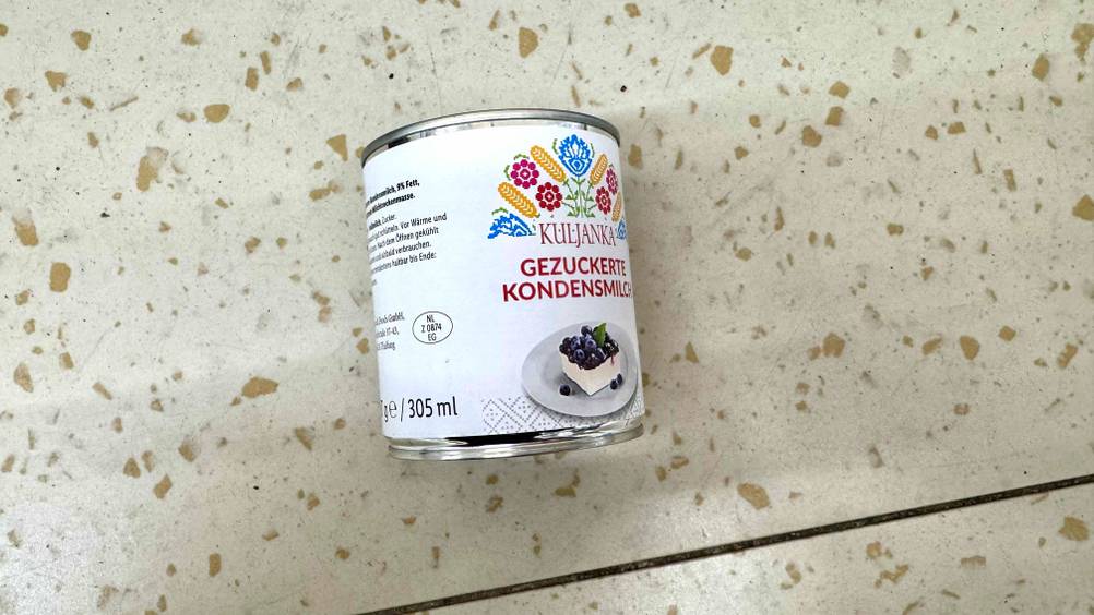 Eine Dose Kondensmilch im Test liegt auf einem Boden.