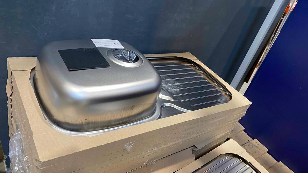 Edelstahlspüle im Test: ein in Karton verpacktes Edelstahl-Modell liegt über mehreren Ausführungen seiner Art im Verkauf.