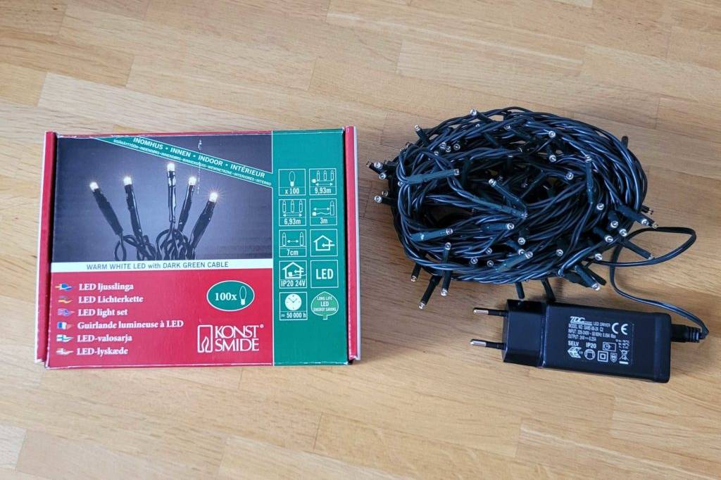 Im Test: eine LED-Weihnachtsbeleuchtung liegt ausgepackt neben dem Verpackungskarton auf einem Holzboden.
