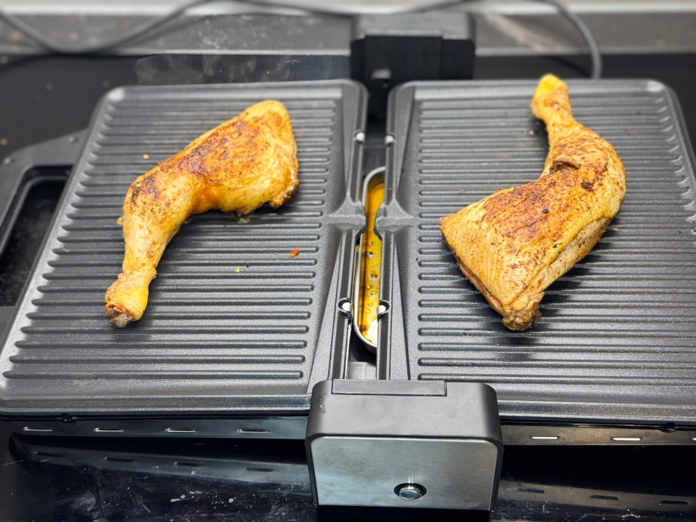 Hähnchenschenkel werden auf dem WMF-Kontaktgrill Lono im Test gegrillt.