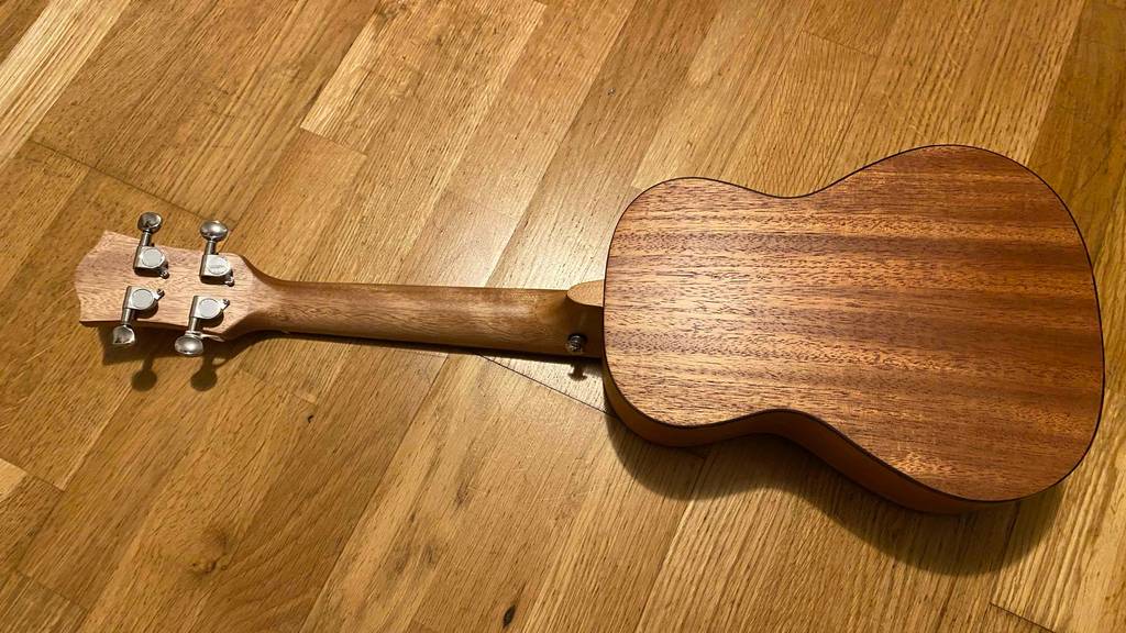 Getestete Konzert-Ukulele befindet sich mit der Rückseite nach oben auf dem Boden.