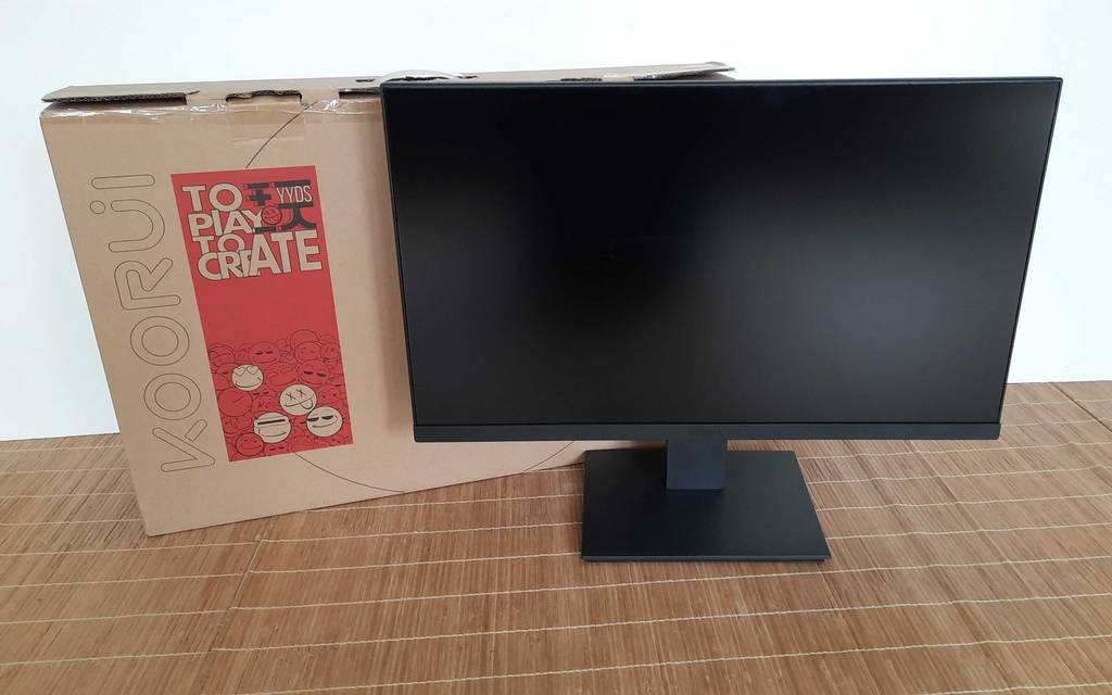 24-Zoll-Monitore im Test: Ein Modell der Marke KOORUI steht neben seinem Originalkarton auf einer Bast-Unterlage.
