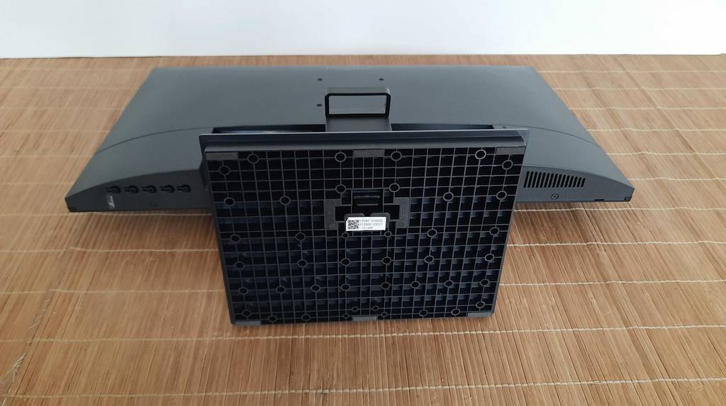Ansicht der Unterseite des schwarzen Standfußes von einem Koorui 24-Zoll-Monitor im Test, der auf einer hellbraunen Bastmatte liegt.