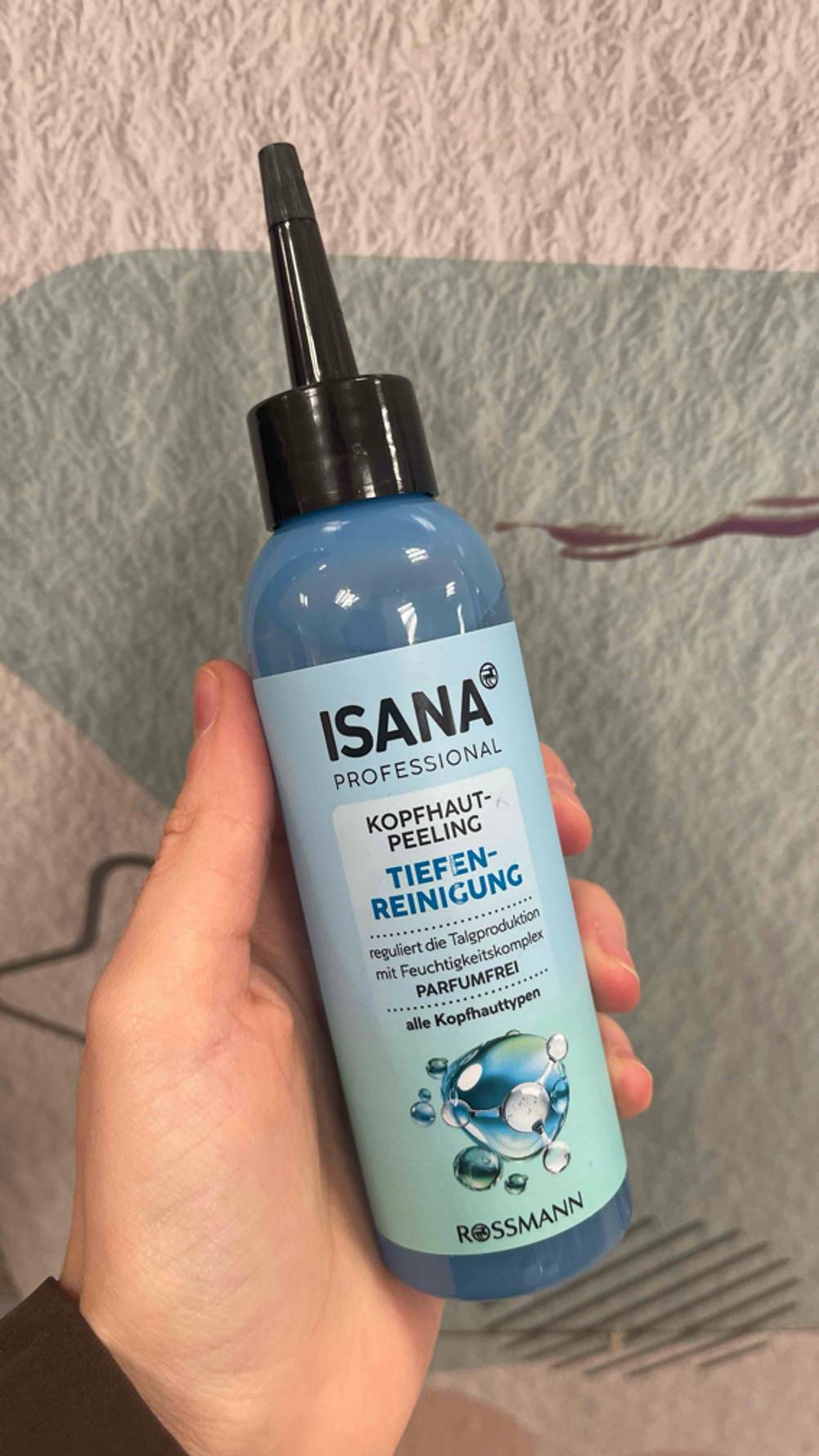 Getestet: Eine Hand hält die Flasche mit dem Kopfhaut-Peeling im Test.