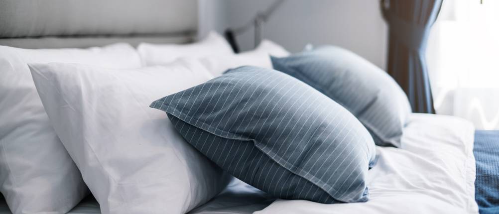 Kopfkissen liegen auf einem Bett.