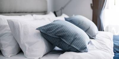 Kopfkissen liegen auf einem Bett.