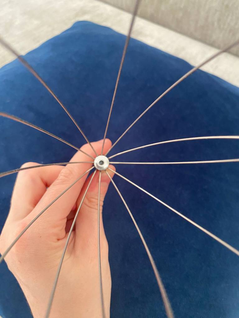 Blick von oben auf eine von einer Hand gehaltenen, geöffneten Kopfmassage-Spinne im Test.