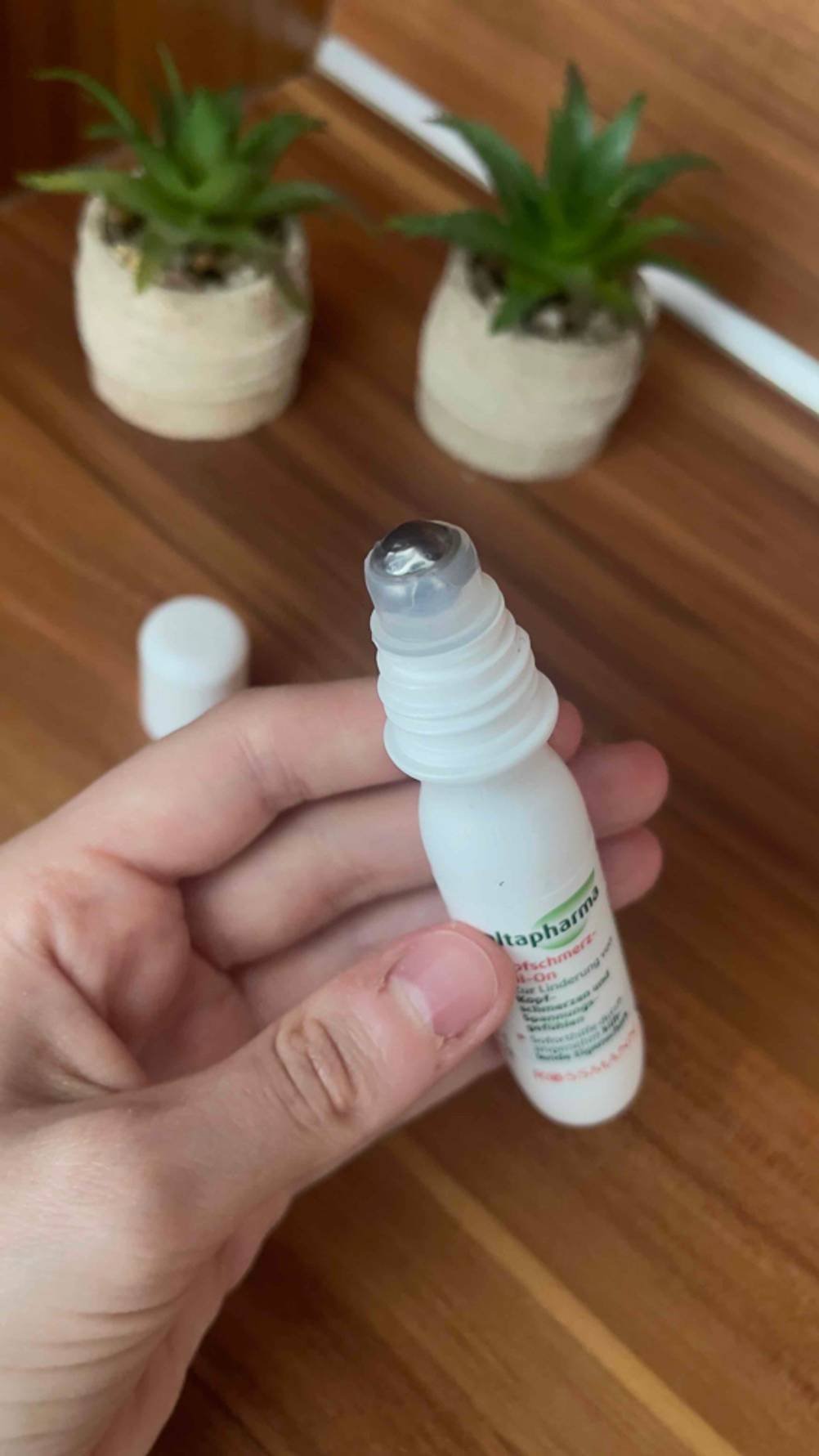 Eine Hand hält den geöffneten Kopfschmerz-Roll-on im Test.