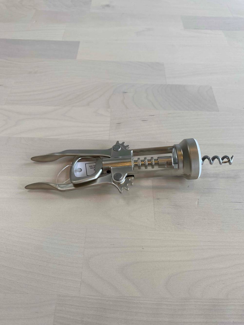 Ein getesteter Korkenzieher auf einem Holztisch horizontal.