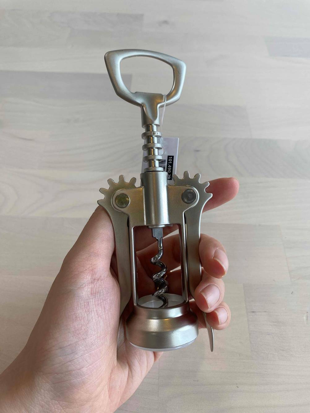 Eine Hand hält einen silbernen Korkenzieher